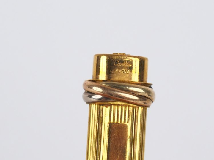 CARTIER, Must Stylo bille en plaqué or, à décor de cannelures.  Signé.