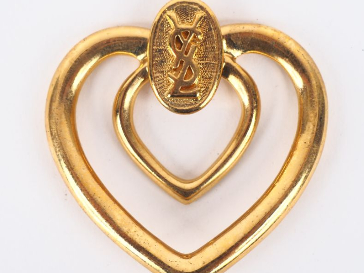 YVES SAINT LAURENT  Pendentif (?) ajouré en métal doré en forme de cœu