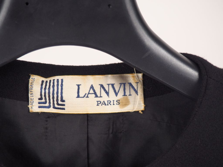 LANVIN,  Veste noire à volant.  Fermeture par boutons gainés de tissu.
