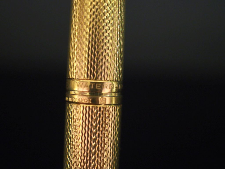 WATERMAN,  Stylo plume en plaqué or, à décor guilloché.  Plume en or j