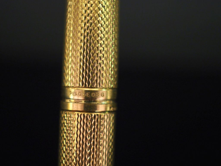 WATERMAN,  Stylo plume en plaqué or, à décor guilloché.  Plume en or j