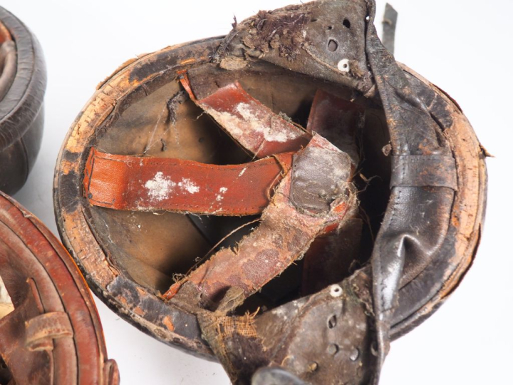 Lot comprenant cinq casques en cuir et une casquette. (état d'usage)