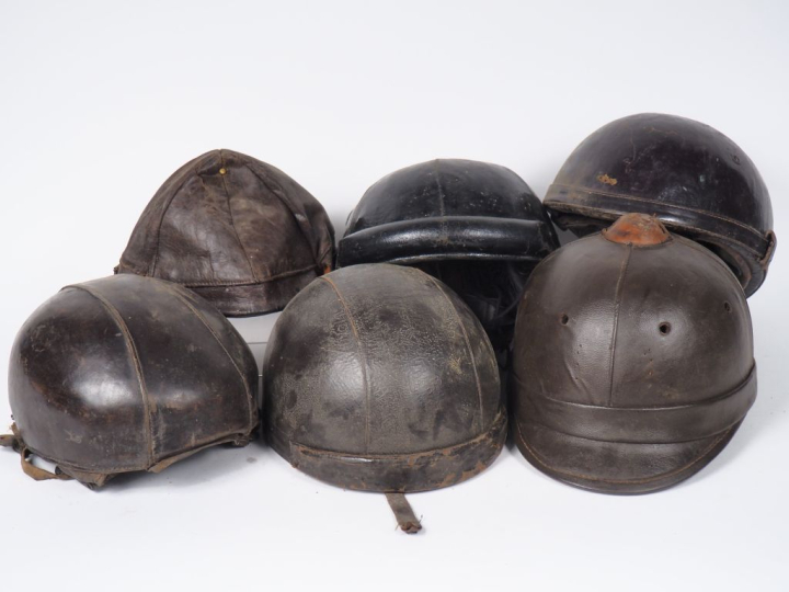 Lot de cinq casques en cuir et une casquette. (état d'usage)