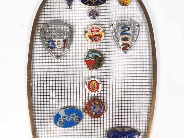 Calandre d'automobile ornée de seize différents macarons automobiles. 