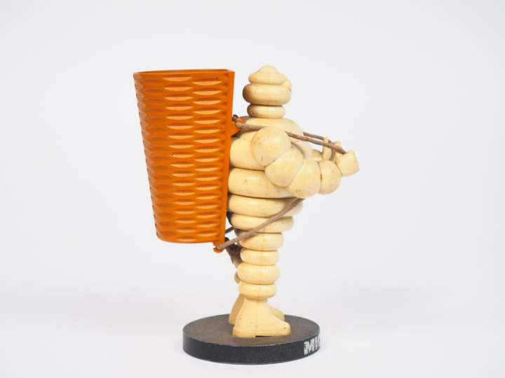 MICHELIN.  Porte crayon Bibendum vendangeur en plastique et métal. H. 