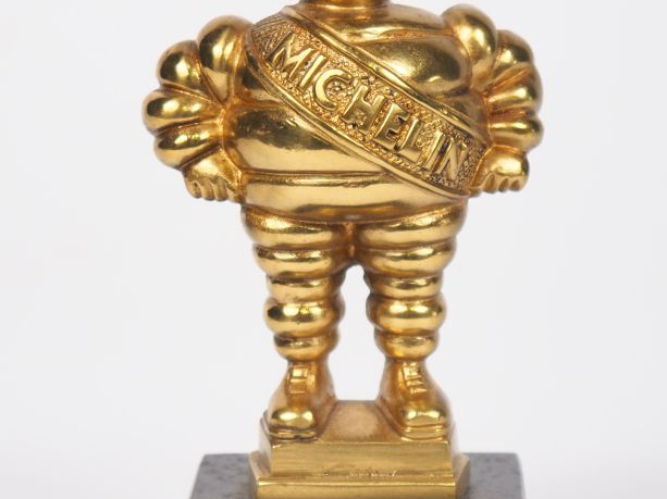 MICHELIN.  Bibendum, sujet en bronze doré sur un socle en marbre noir.