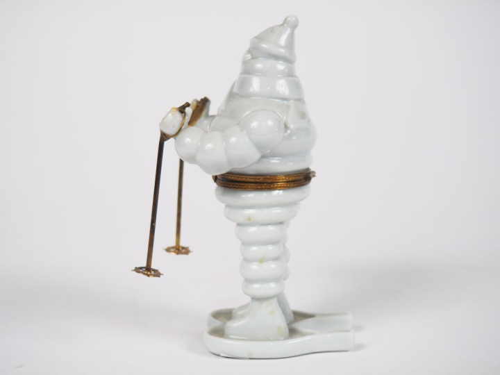 MICHELIN.  Bibendum skieur, boîte en porcelaine de Limoges. H. 14 cm.