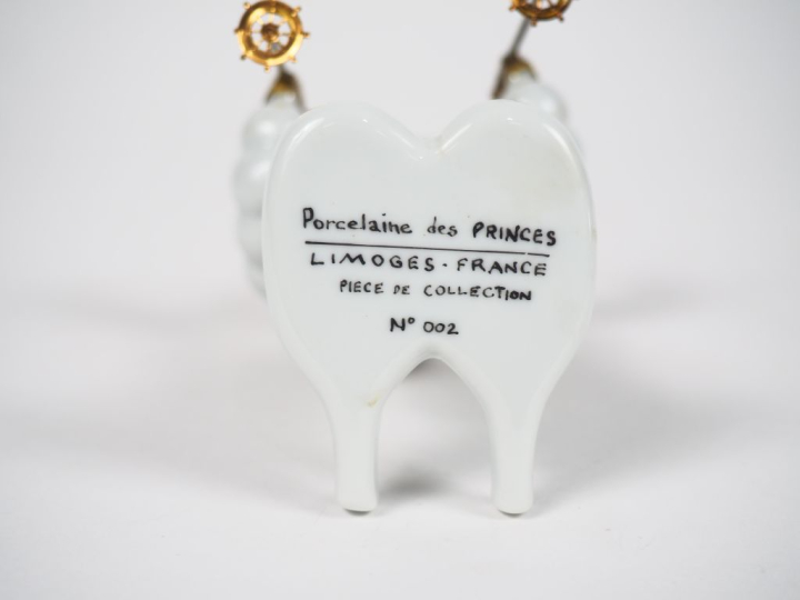 MICHELIN.  Bibendum skieur, boîte en porcelaine de Limoges. H. 14 cm.