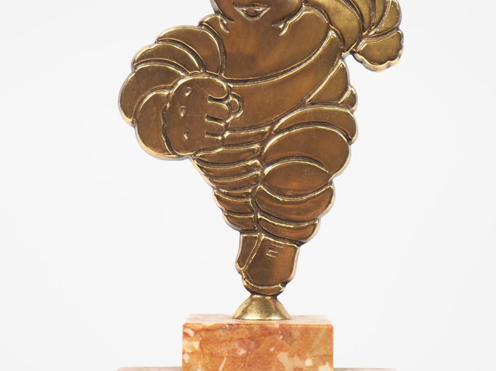 MICHELIN.  Bibendum courant, sujet en bronze sur un socle en marbre. H