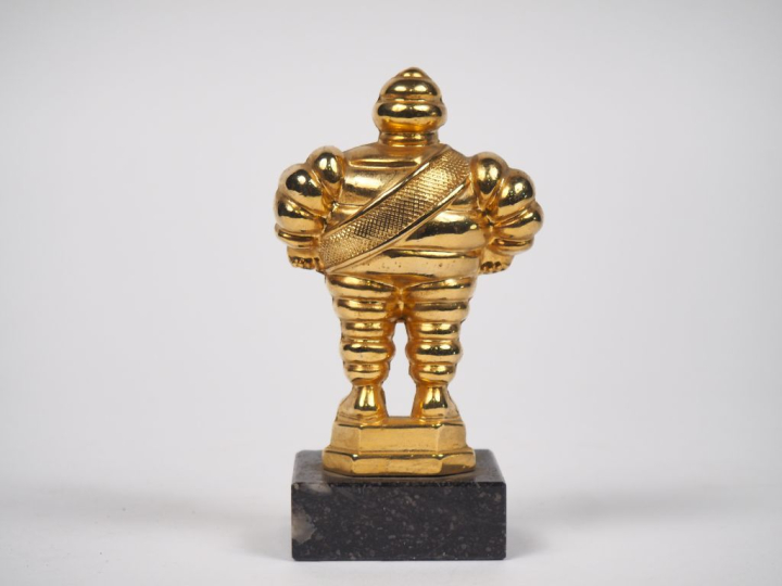 MICHELIN.  Bibendum, sujet en bronze doré sur un socle en marbre noir.