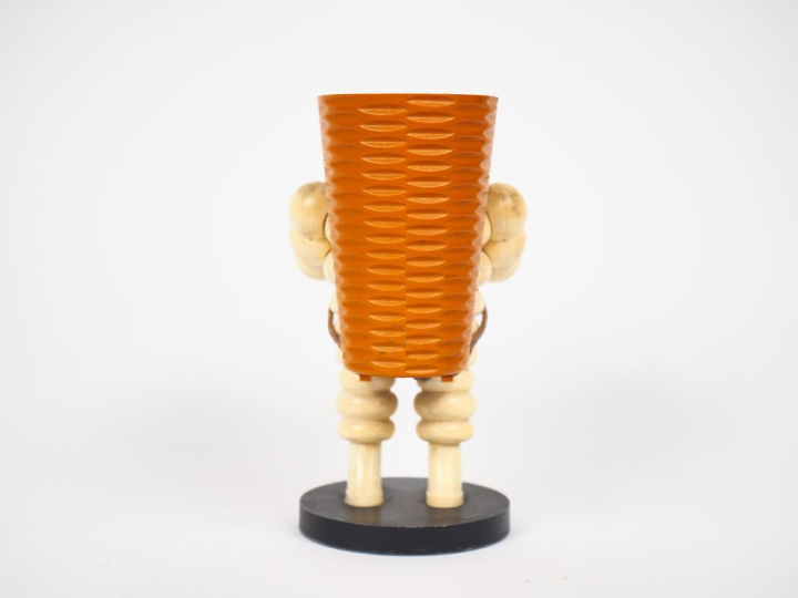 MICHELIN.  Porte crayon Bibendum vendangeur en plastique et métal. H. 