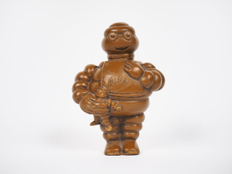 Vente aux enchères MICHELIN. Bibendum, sujet en résine ocre. H. 9,5 cm.