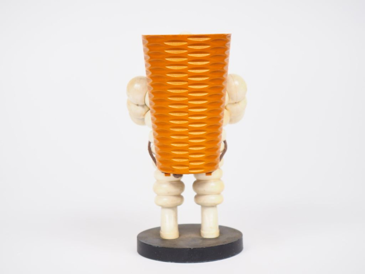 MICHELIN.  Porte crayon Bibendum vendangeur en plastique et métal. H. 