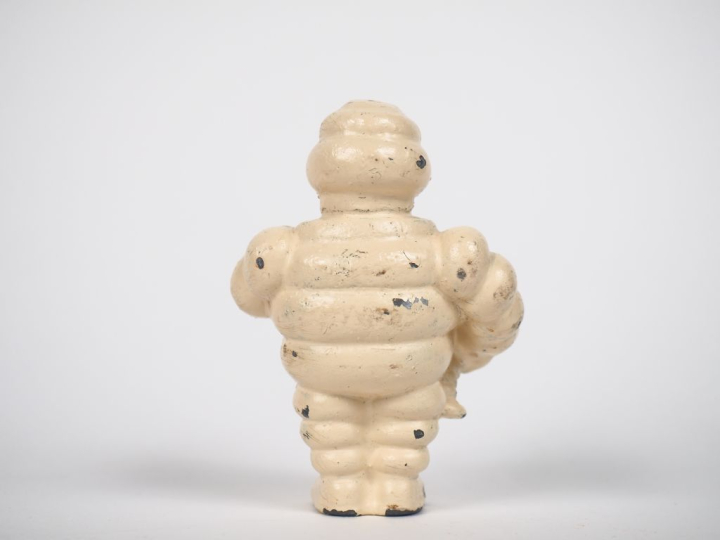 MICHELIN. Bibendum, sujet en fonte blanc. H. 9,5 cm.
