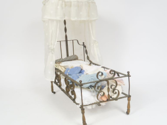 Vente aux enchères 	Lit de poupée fin XIXème en métal pied bois à roulettes très jolie fa