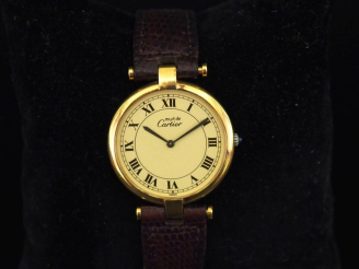 Vente aux enchères CARTIER, Must  Montre bracelet, boitier en argent plaqué or.  Cadran à