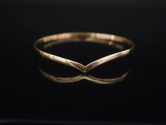 Vente aux enchères Bracelet jonc de forme stylisé en or jaune 750.  Diam. 7 cm Poids. 10,