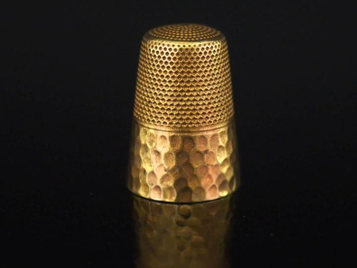 Dé en or jaune 750, à décor partiellement martelé.  H. 2,5 cm Poids. 6