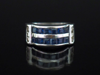 Vente aux enchères Bague pont en or blanc 750, sertie de deux lignes de saphirs calibrées