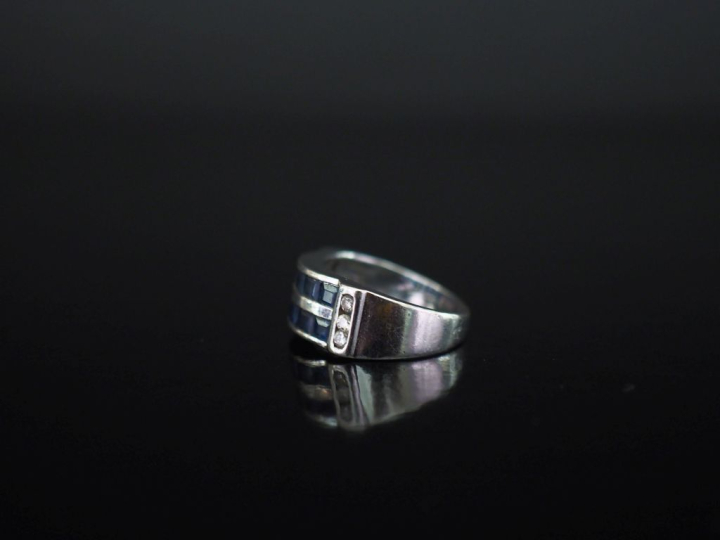 Bague pont en or blanc 750, sertie de deux lignes de saphirs calibrées