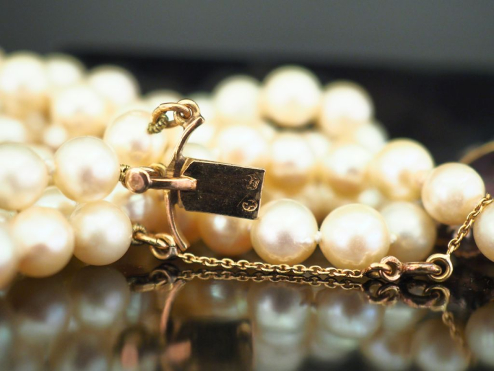 Collier triple rangs de perles de culture blanches, agrémenté d'un jol