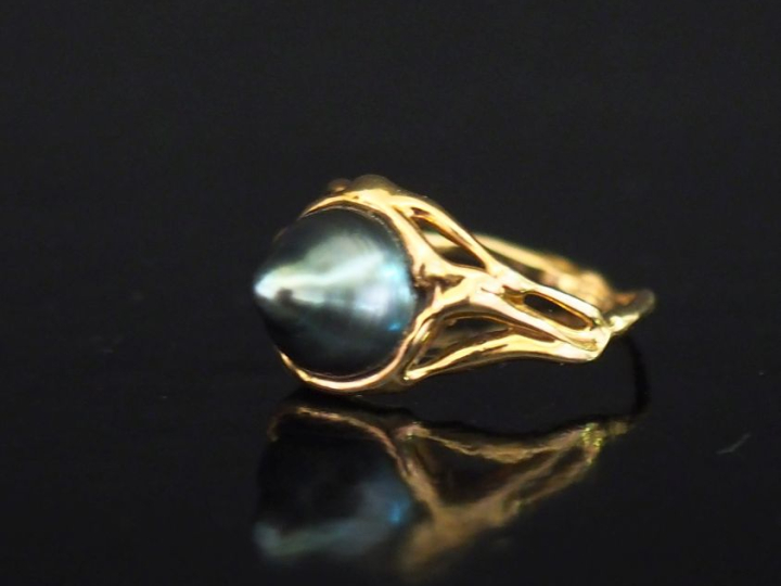 Bague en or jaune 750, sertie en son centre d'une perle de forme pyram
