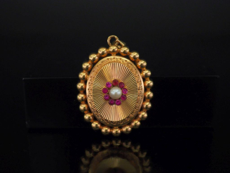 Vente aux enchères 	Pendentif ovale en or jaune 750, à décor en son centre d’un motif de 