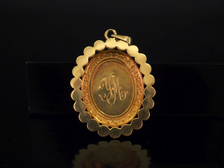 	Pendentif ovale en or jaune 750, à décor en son centre d’un motif de 