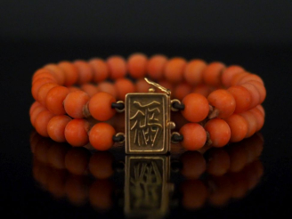 Vente aux enchères Bracelet souple deux rangs de perles de corail.  Fermoir en or jaune 7