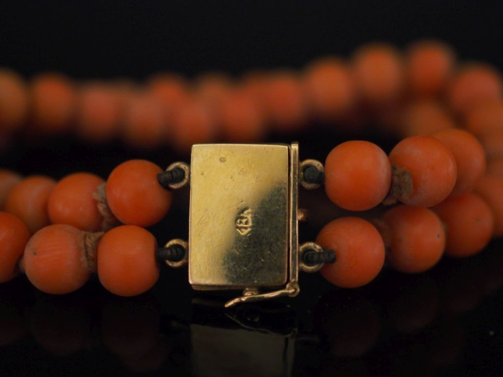 Bracelet souple deux rangs de perles de corail.  Fermoir en or jaune 7