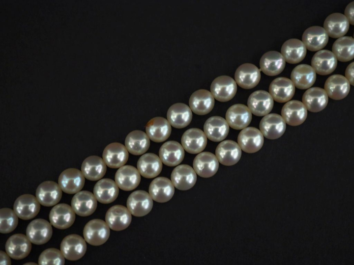 Bracelet triple rangs de perles blanches.  Fermoir en or jaune 750, à 