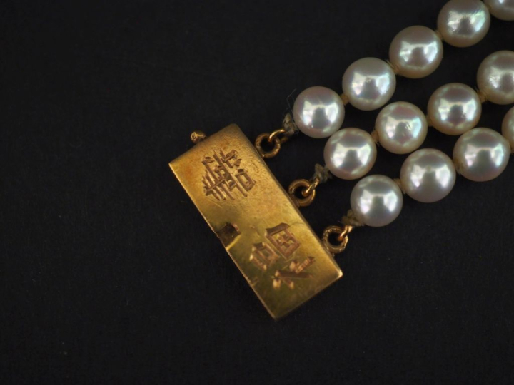 Bracelet triple rangs de perles blanches.  Fermoir en or jaune 750, à 