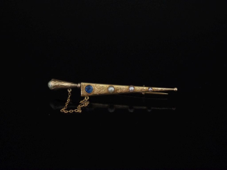 Vente aux enchères Broche en forme de poignard, le fourreau en or jaune 750, serti de tro