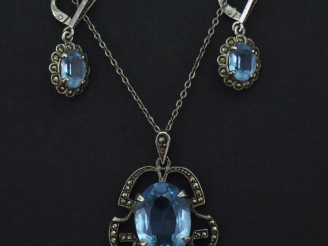 Vente aux enchères Pendentif ajouré en argent, serti en son centre d'une pierre bleu ciel