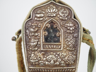 Vente aux enchères Tibet XXème. Reliquaire Gau en argent repoussé des huit emblèmes boudd