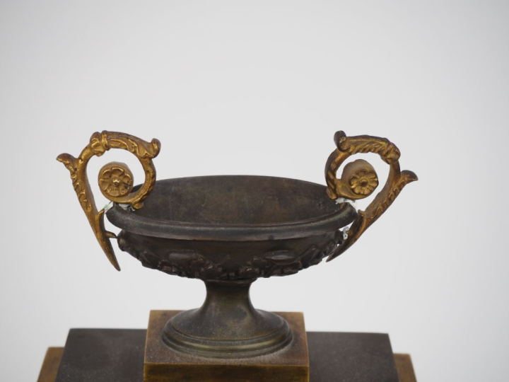 Pendule borne Restauration en bronze patiné et doré, à décor d'amours 