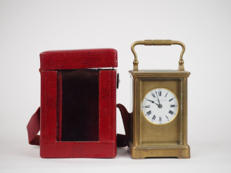 Vente aux enchères Dans son écrin en cuir rouge, pendulette de voyage en bronze et crista