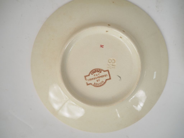 SARREGUEMINES. 10 assiettes en faïence polychrome modèle "courses". Di