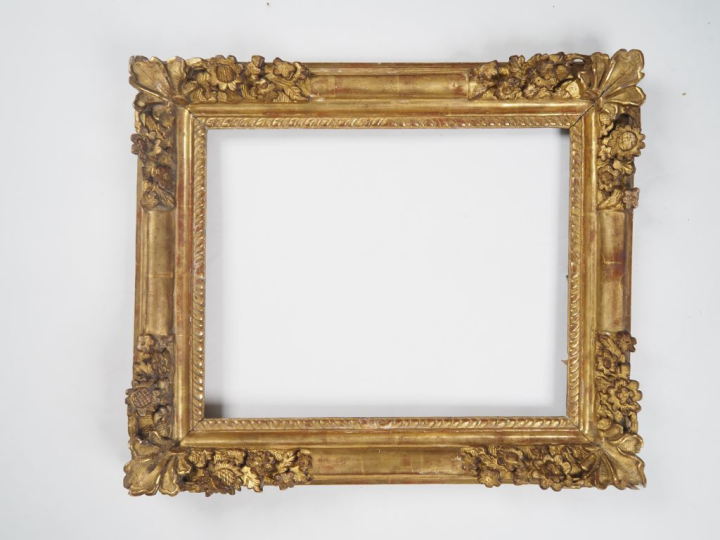 Cadre XVIIIème en bois et stuc doré, à décor sculpté de fleurs. Dim. 5