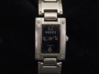 Vente aux enchères GUCCI,  Montre bracelet de dame en acier.  Cadran rectangulaire à fond