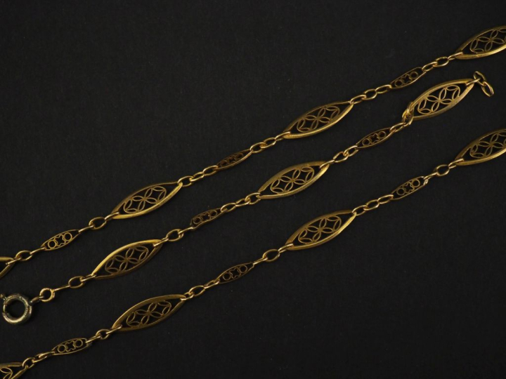 Giletière en or jaune 750, composée de maillons ajourés et filigranés.