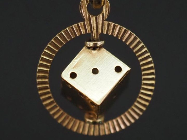 Pendentif circulaire en or jaune 750, à décor d'un dé mobile sur un ax