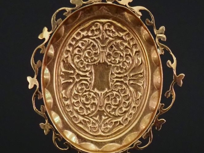 Pendentif ovale en or jaune 750, à décor de rinceaux feuillagés.  Joli