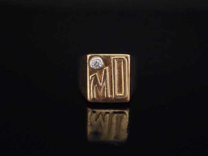 Bague de forme chevalière en or jaune 750, agémentée d'un diamant sert