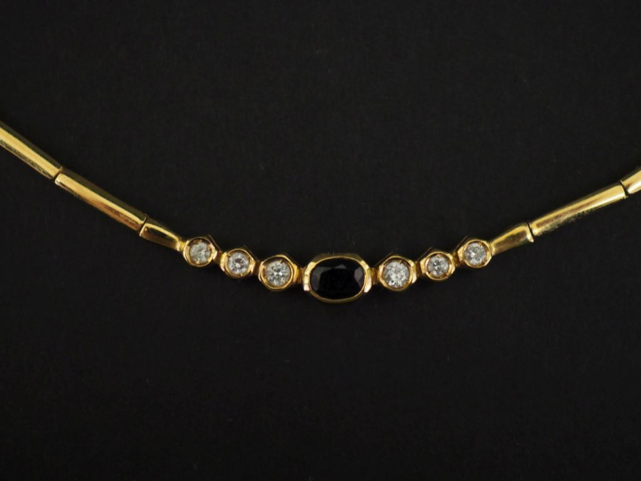 Collier articulé en or jaune 750, orné en son centre d'un saphir épaul