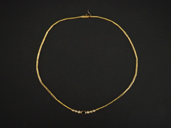 Collier articulé en or jaune 750, orné en son centre d'un saphir épaul