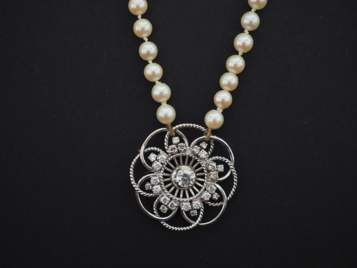Collier de perles blanches, agrémenté en son centre d'une rosace ajour