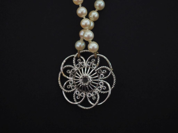 Collier de perles blanches, agrémenté en son centre d'une rosace ajour