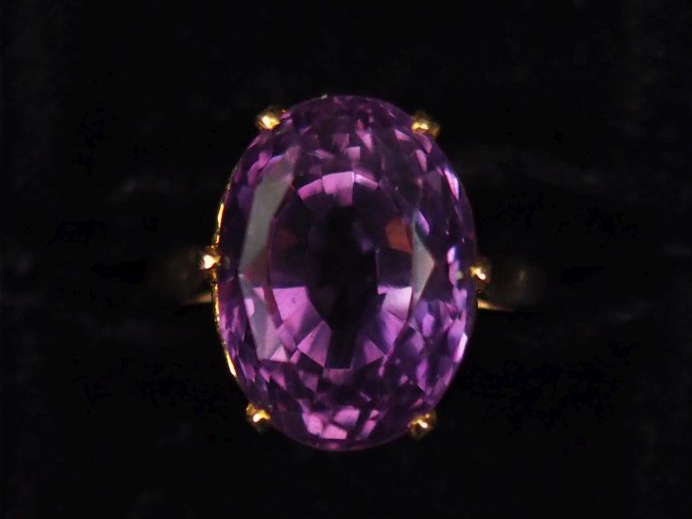 Bague en or jaune 750, sertie d'une verroterie mauve.  Jolie monture a