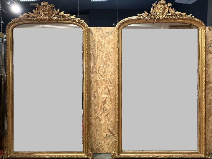 Rare paire de glaces Napoléon III en bois et stuc doré, à décor de feu